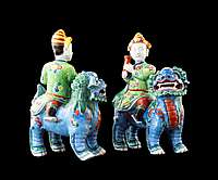 GG: Pair of Chinese porcelain famille rose figures of riders on Buddhist lions