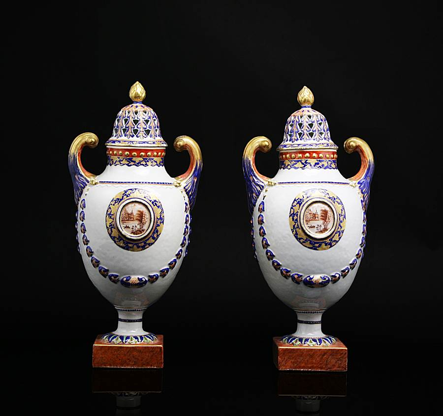 pair of chinese export porcelain pistol handled urns with reticulated covers